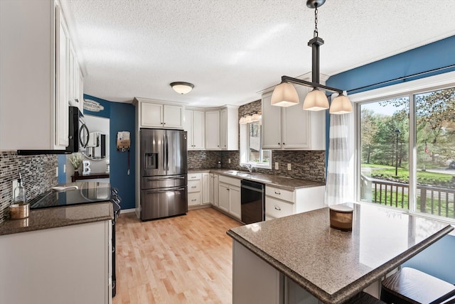 kitchen with stainless steel fridge, dishwasher, a textured ceiling, decorative backsplash, and a sink