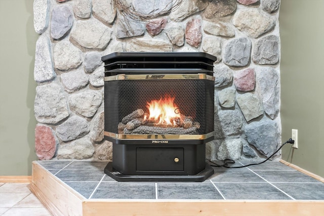 detailed view of baseboards, a warm lit fireplace, and a wood stove