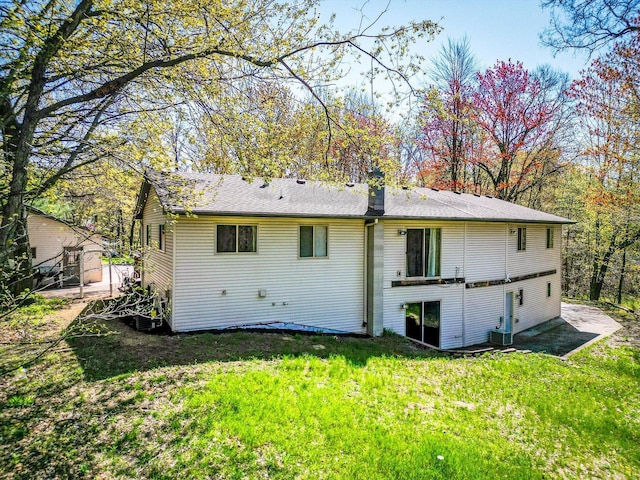 back of property with a lawn and central AC unit