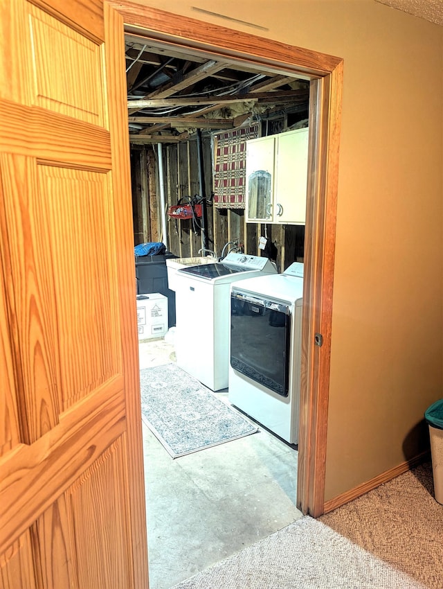 clothes washing area featuring washer and dryer and cabinet space