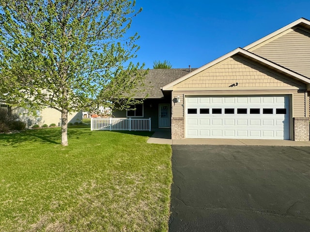 single story home featuring a front lawn, an attached garage, covered porch, brick siding, and driveway