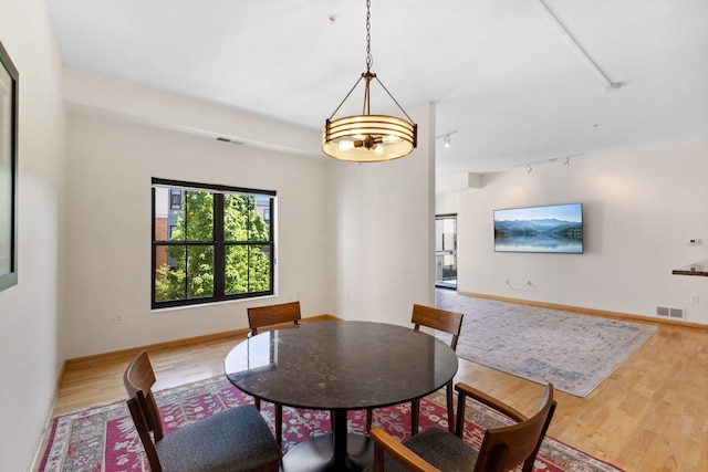 3709 Grand Way Unit 315, Saint Louis Park, MN 55416 - dining area with rail lighting, wood finished floors, and baseboards