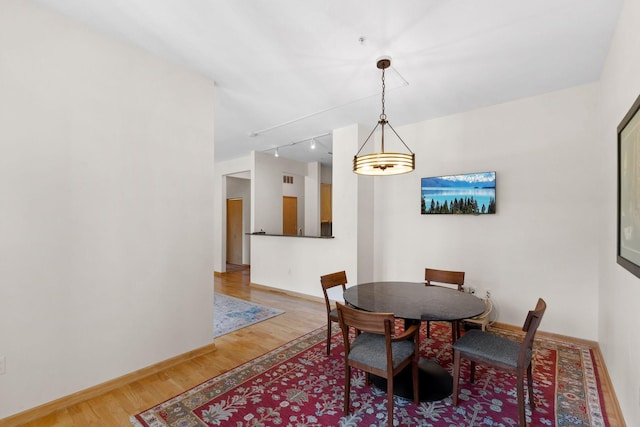 3709 Grand Way Unit 315, Saint Louis Park, MN 55416 - dining area featuring light wood finished floors, rail lighting, and baseboards