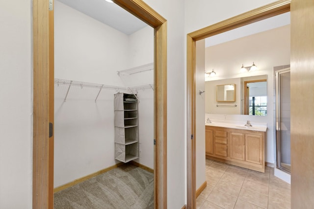 3709 Grand Way Unit 315, Saint Louis Park, MN 55416 - bathroom with a shower stall, a spacious closet, vanity, baseboards, and tile patterned flooring