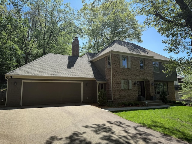 14700 Minnehaha Pl, Minnetonka, MN 55391 - view of front facade featuring asphalt driveway, a garage, a front lawn, brick siding, and a chimney