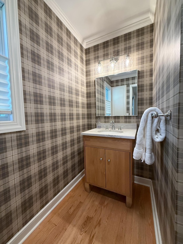 14700 Minnehaha Pl, Minnetonka, MN 55391 - bathroom featuring wallpapered walls, wood finished floors, ornamental molding, vanity, and baseboards