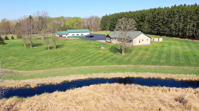 view of subject property featuring a large body of water and a heavily wooded area