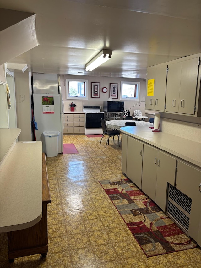 211 1st Ave, Osakis, MN 56360 - kitchen with light flooring, light countertops, plenty of natural light, and freestanding refrigerator