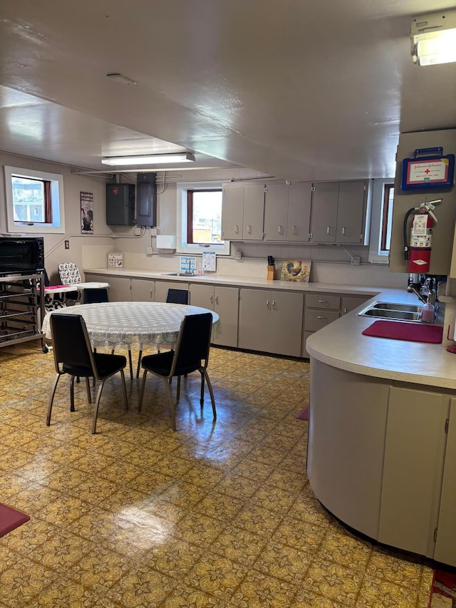 211 1st Ave, Osakis, MN 56360 - kitchen featuring a sink, light countertops, gray cabinetry, and electric panel