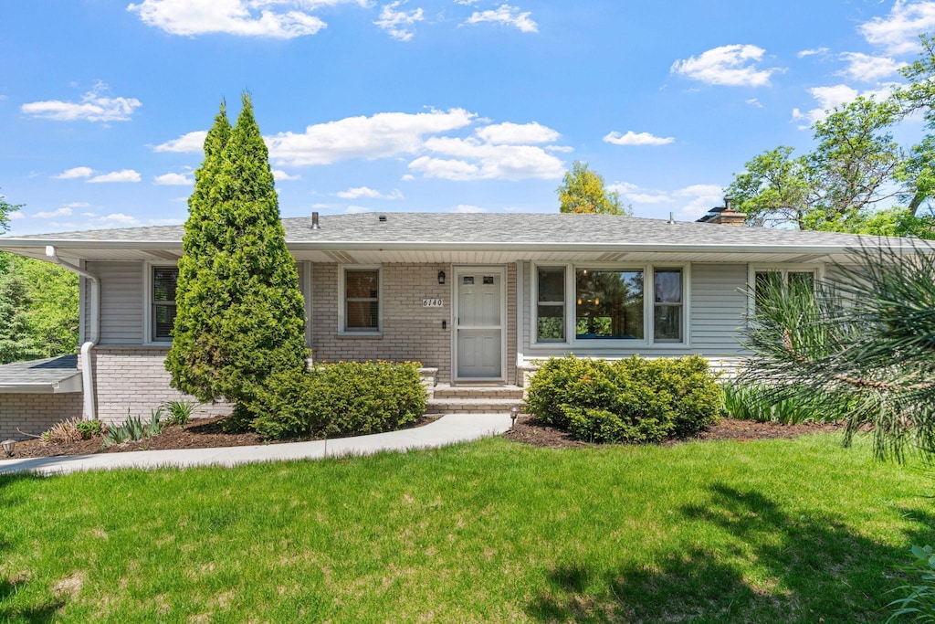 6140 Glenwood Ave, Golden Valley, MN 55422 - ranch-style house with brick siding, a front lawn, and a chimney