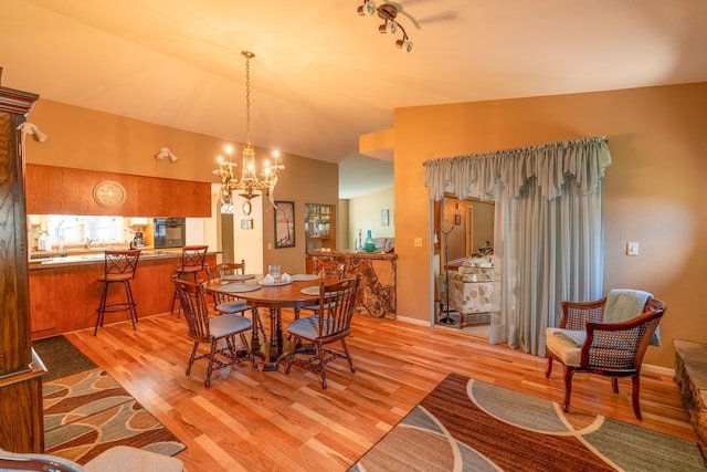 402 2nd Ave SE, Mapleton, MN 56065 - dining space with light wood-style flooring, a chandelier, and vaulted ceiling