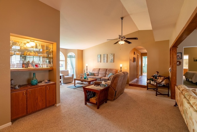 402 2nd Ave SE, Mapleton, MN 56065 - living area featuring light carpet, arched walkways, vaulted ceiling, a ceiling fan, and baseboards