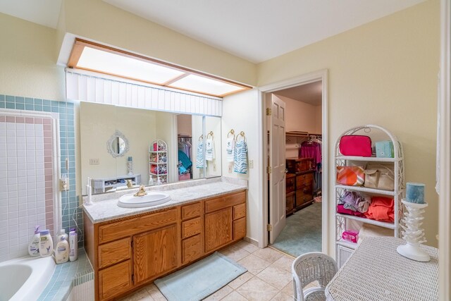 402 2nd Ave SE, Mapleton, MN 56065 - bathroom with tiled tub, vanity, a spacious closet, tile patterned flooring, and a tile shower