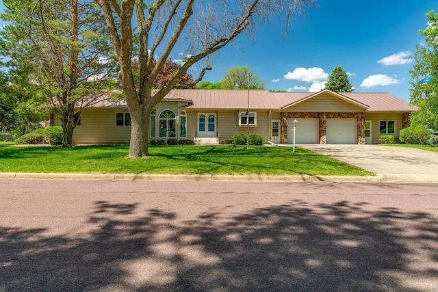 402 2nd Ave SE, Mapleton, MN 56065 - ranch-style house with an attached garage, a front yard, metal roof, and driveway
