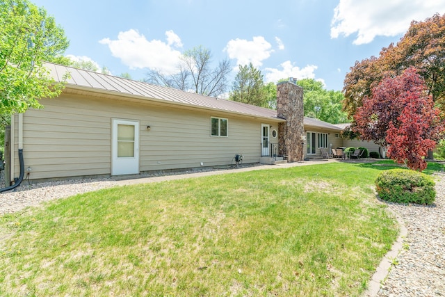 402 2nd Ave SE, Mapleton, MN 56065 - rear view of property with a yard, metal roof, a patio area, a chimney, and a standing seam roof