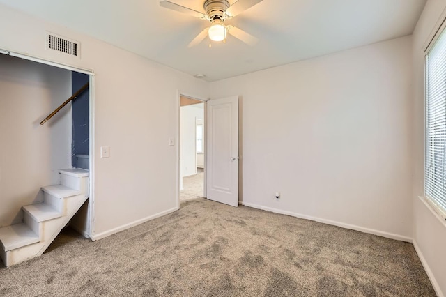 unfurnished bedroom featuring carpet, baseboards, and ceiling fan