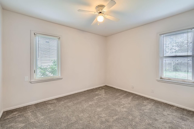 carpeted spare room with healthy amount of natural light, baseboards, and a ceiling fan