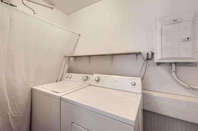 laundry room featuring electric panel and washing machine and clothes dryer