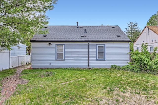 back of house featuring roof with shingles