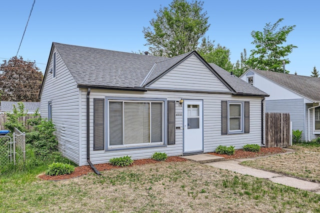 view of front of house with fence and a shingled roof