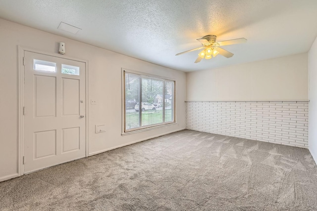 carpeted foyer with healthy amount of natural light, a textured ceiling, and a ceiling fan