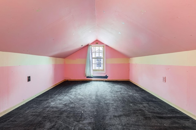additional living space featuring carpet floors, lofted ceiling, and baseboards