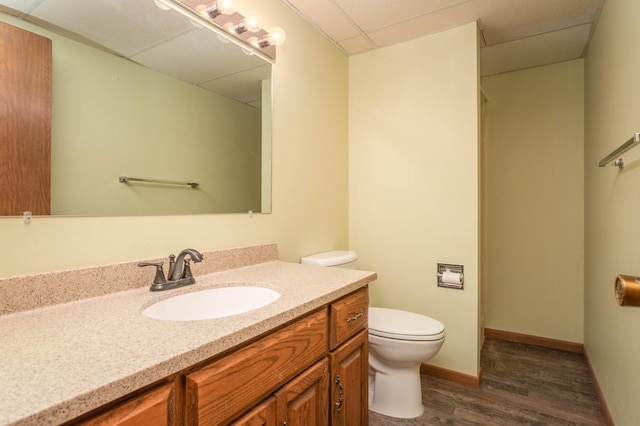 1346 Latoka Drive Ct SW, Alexandria, MN 56308 - bathroom with wood finished floors, toilet, vanity, baseboards, and a drop ceiling