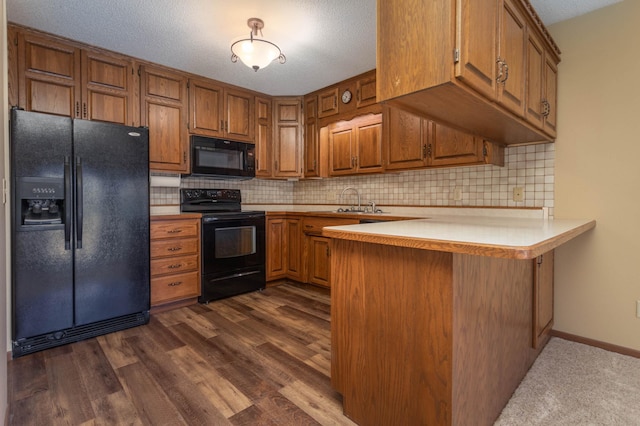 1346 Latoka Drive Ct SW, Alexandria, MN 56308 - kitchen with black appliances, a peninsula, brown cabinetry, light countertops, and a textured ceiling