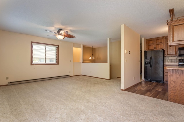 1346 Latoka Drive Ct SW, Alexandria, MN 56308 - unfurnished living room featuring a baseboard heating unit, dark carpet, and a ceiling fan