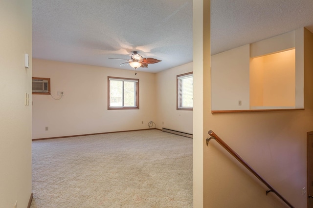 1346 Latoka Drive Ct SW, Alexandria, MN 56308 - spare room featuring baseboard heating, a ceiling fan, a wall mounted AC, light colored carpet, and a textured ceiling