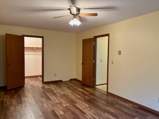 1346 Latoka Drive Ct SW, Alexandria, MN 56308 - unfurnished bedroom with dark wood-type flooring, a textured ceiling, a walk in closet, a closet, and a ceiling fan