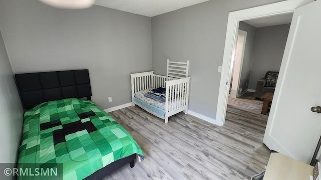 bedroom with wood finished floors and baseboards