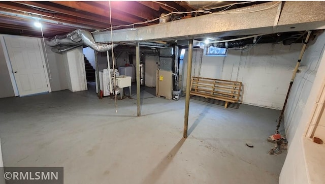 unfinished basement featuring stairs and heating unit