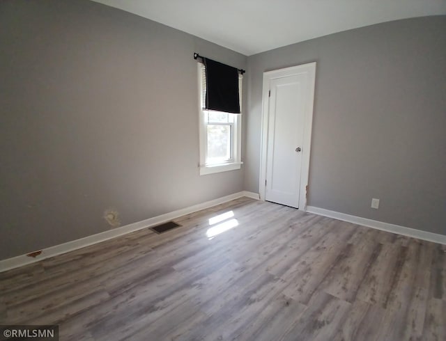 spare room featuring wood finished floors and baseboards