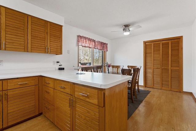 20441 Elmwood Rd, Lynden Twp, MN 55320 - kitchen featuring a peninsula, light wood finished floors, light countertops, and ceiling fan