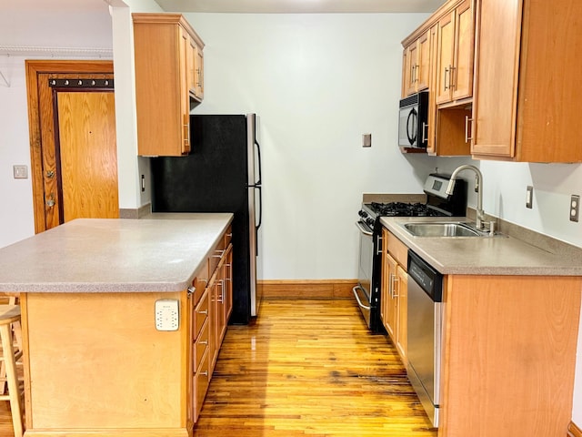 3116 12th Ave S Unit A209, Minneapolis, MN 55407 - kitchen with appliances with stainless steel finishes, light wood-style flooring, a sink, and a peninsula