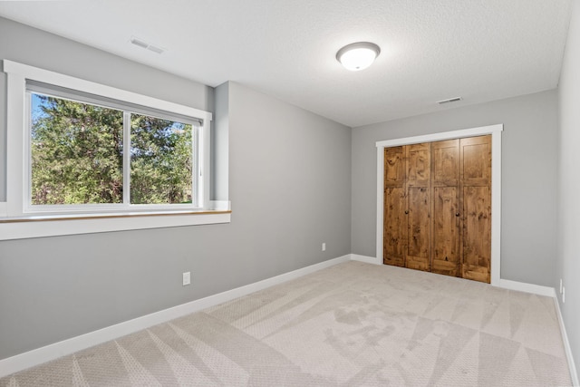 18041 224th Ave NW, Big Lake Twp, MN 55309 - unfurnished bedroom with carpet flooring, baseboards, a closet, and a textured ceiling
