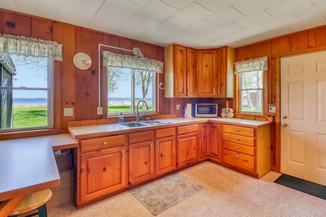 23620 Melissa Dr, Lake View Twp, MN 56501 - kitchen with a sink, brown cabinetry, light countertops, and wooden walls