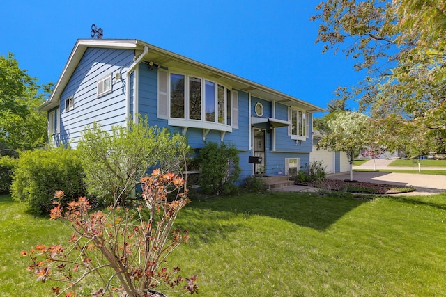 bi-level home with driveway and a front lawn