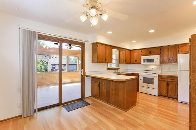 5391 Cottage Ave, White Bear Twp, MN 55110 - kitchen featuring white appliances, light wood finished floors, a peninsula, plenty of natural light, and recessed lighting