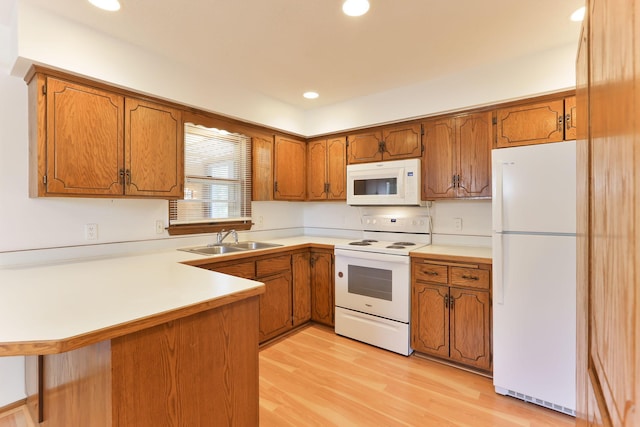 5391 Cottage Ave, White Bear Twp, MN 55110 - kitchen with white appliances, brown cabinetry, a peninsula, light countertops, and light wood-style flooring