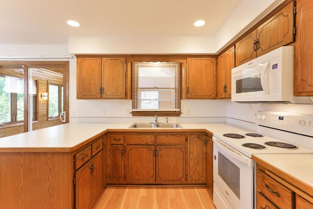 5391 Cottage Ave, White Bear Twp, MN 55110 - kitchen with white appliances, a peninsula, brown cabinetry, light countertops, and light wood finished floors