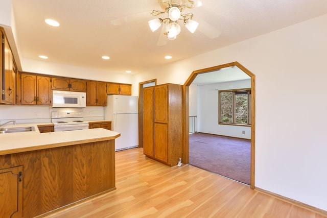 5391 Cottage Ave, White Bear Twp, MN 55110 - kitchen with white appliances, brown cabinets, light wood-style flooring, a peninsula, and light countertops