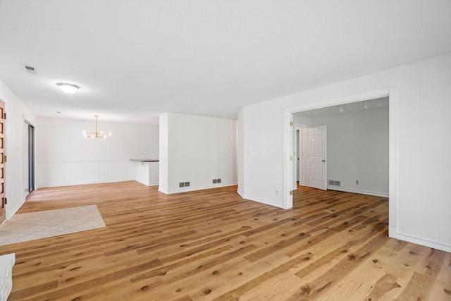 9018 Neill Lake Rd, Eden Prairie, MN 55347 - unfurnished living room with a chandelier, light wood-style flooring, and baseboards