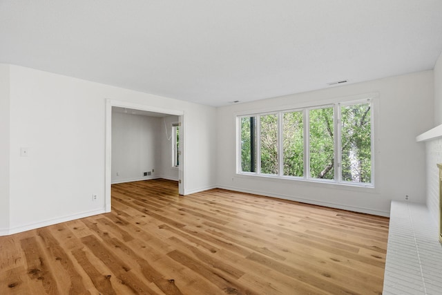 9018 Neill Lake Rd, Eden Prairie, MN 55347 - unfurnished living room with light wood finished floors, baseboards, and a fireplace