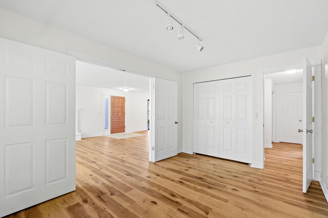 9018 Neill Lake Rd, Eden Prairie, MN 55347 - unfurnished bedroom featuring light wood-style flooring, rail lighting, a closet, and baseboards