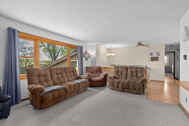 E7065 County Road B, Tainter Twp, WI 54730 - carpeted living area with a chandelier, a textured ceiling, and a ceiling fan