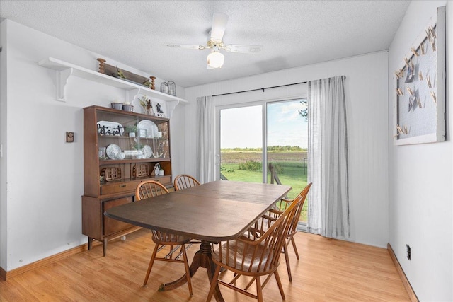 E7065 County Road B, Tainter Twp, WI 54730 - dining room with light wood-type flooring, a textured ceiling, a ceiling fan, and baseboards