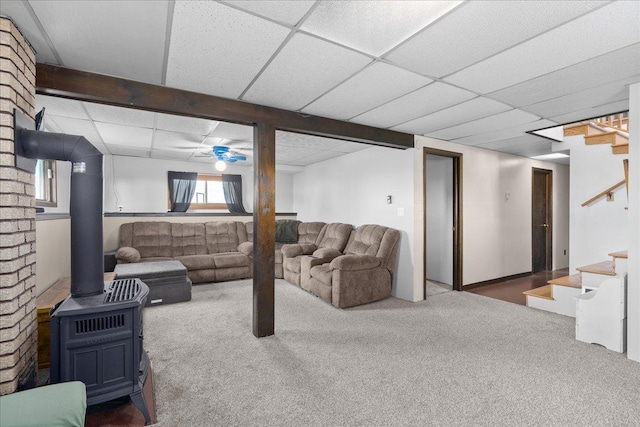 E7065 County Road B, Tainter Twp, WI 54730 - basement featuring carpet flooring, stairway, a paneled ceiling, and a wood stove