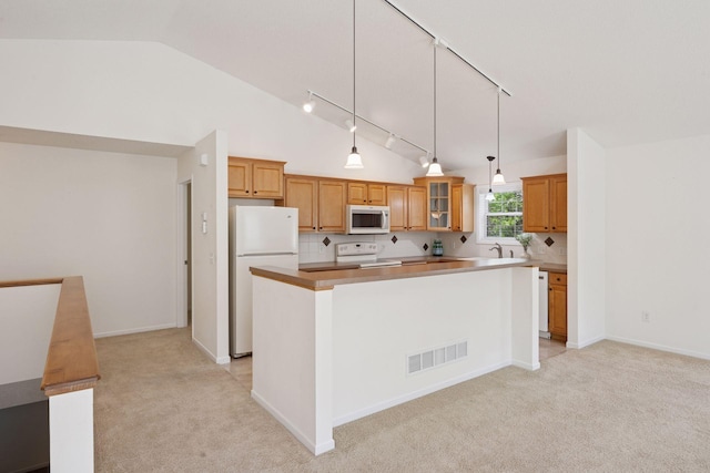 574 Marsh Dr, Delano, MN 55328 - kitchen featuring white appliances, track lighting, vaulted ceiling, a kitchen island, and light carpet